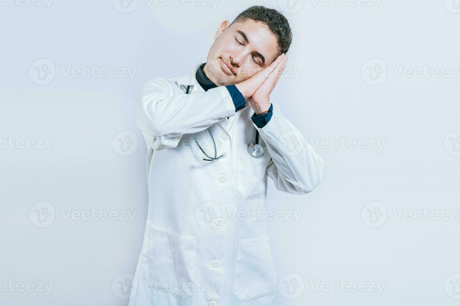 jovem médico fazer dormir gesto isolado. bonito médico fazer dormir gesto com Palmeiras em dele bochechas foto