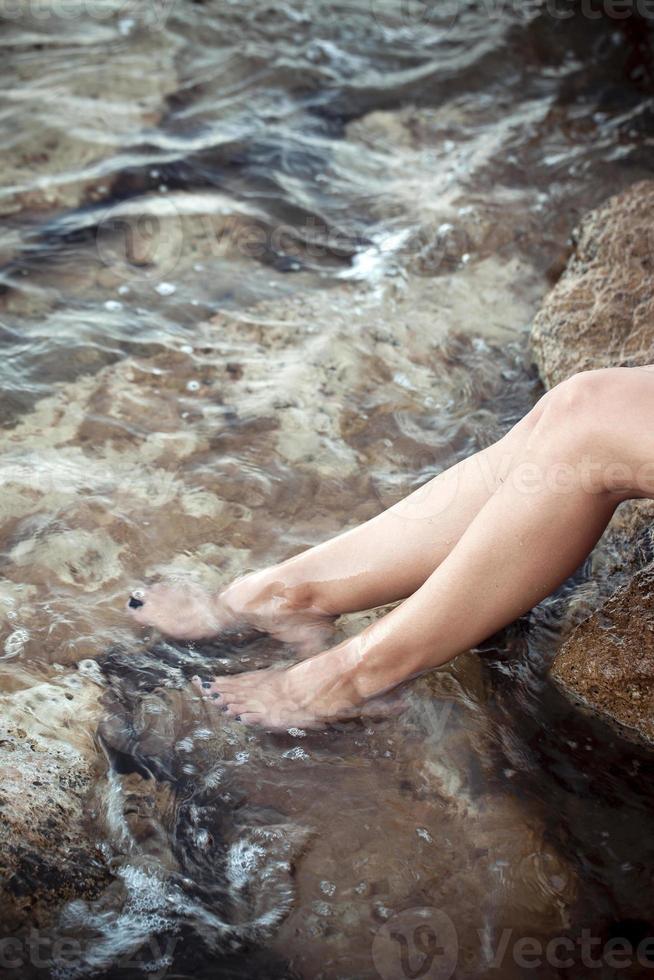 pé de mulher jovem na água do mar limpa foto