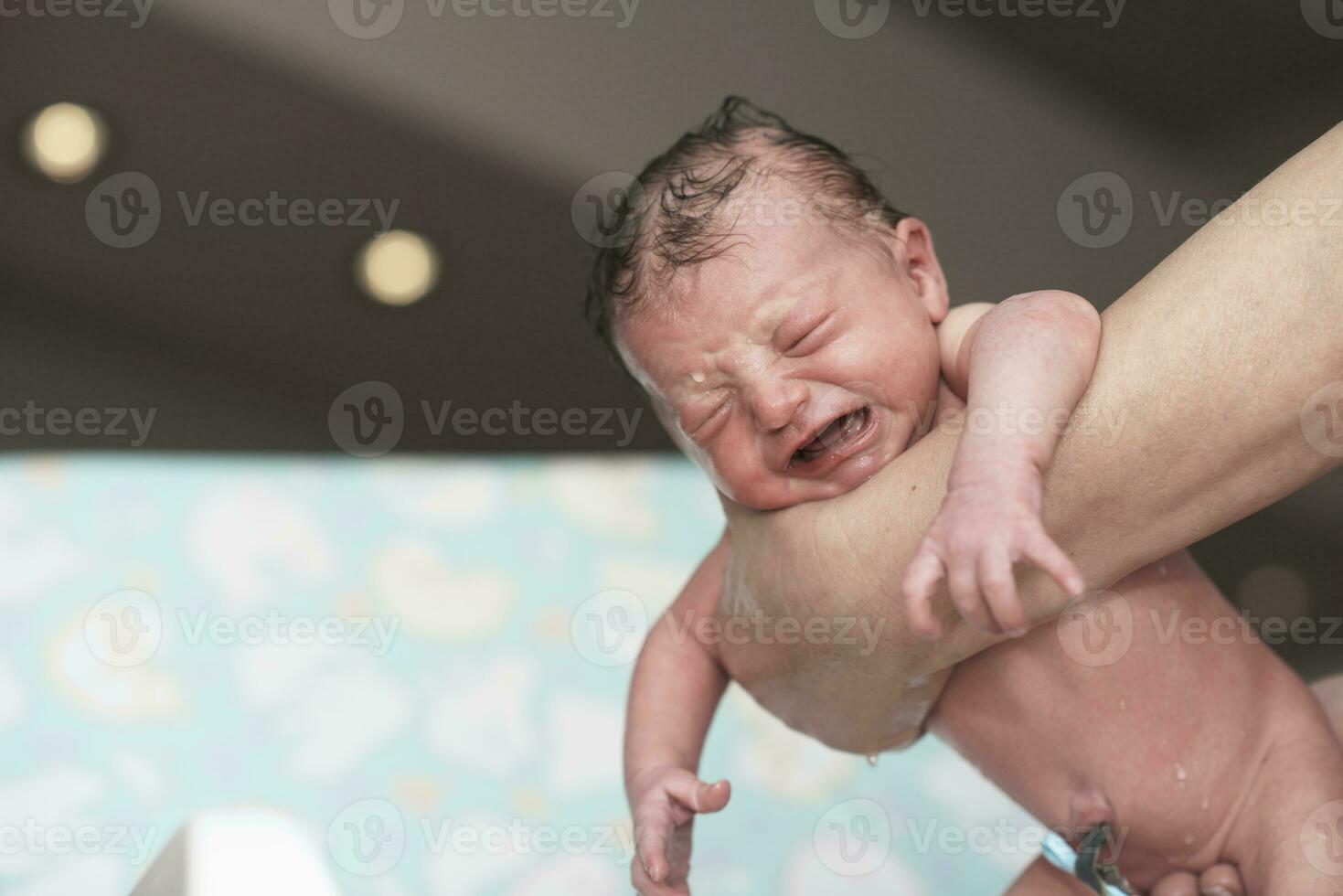 menina recém-nascida tomando um primeiro banho foto