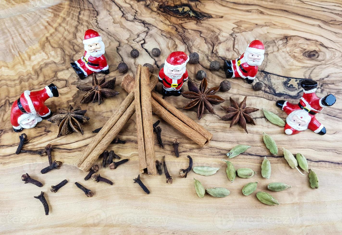 bonecos de papai noel e especiarias de natal em madeira de oliveira foto