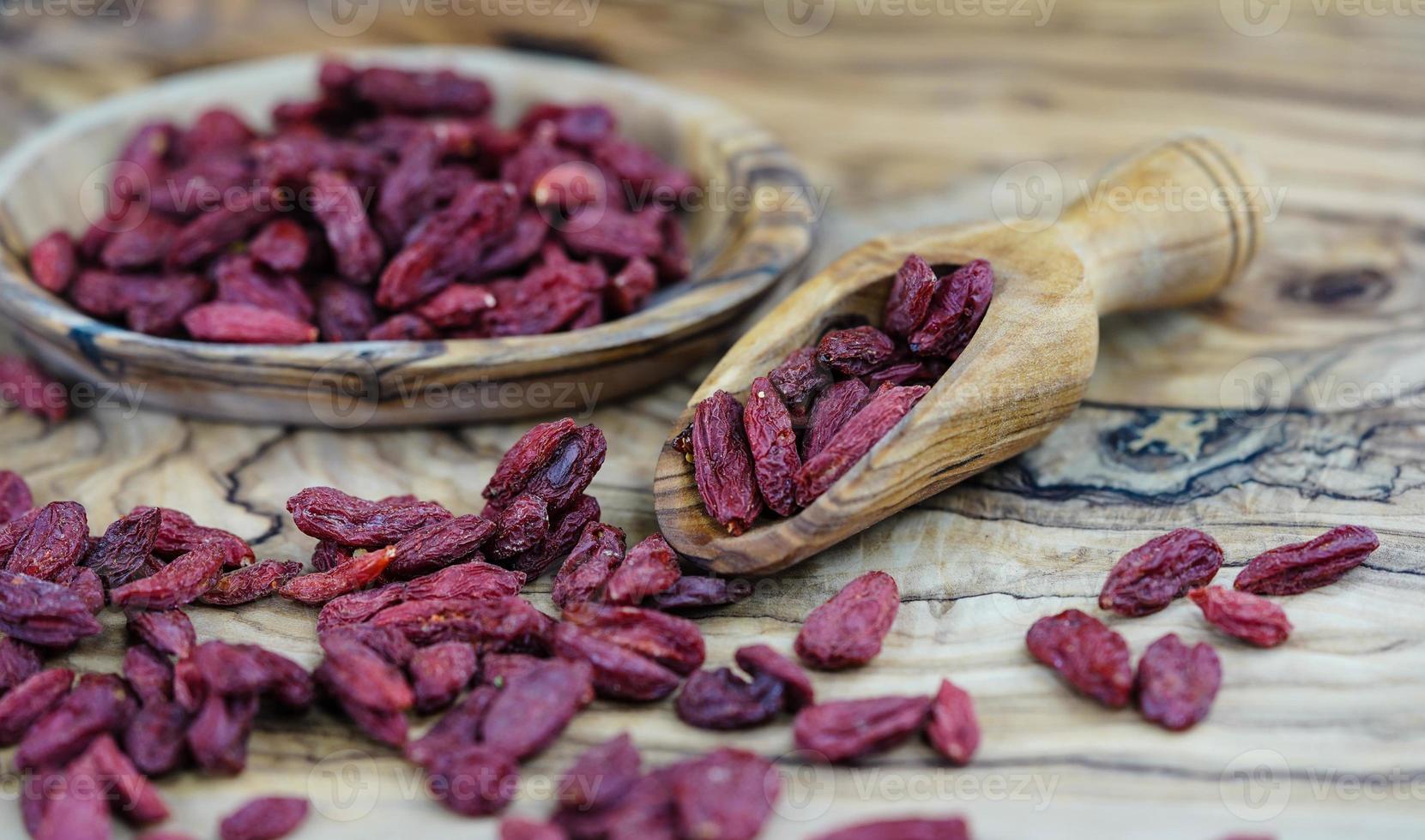 bagas de goji secas em madeira de oliveira foto