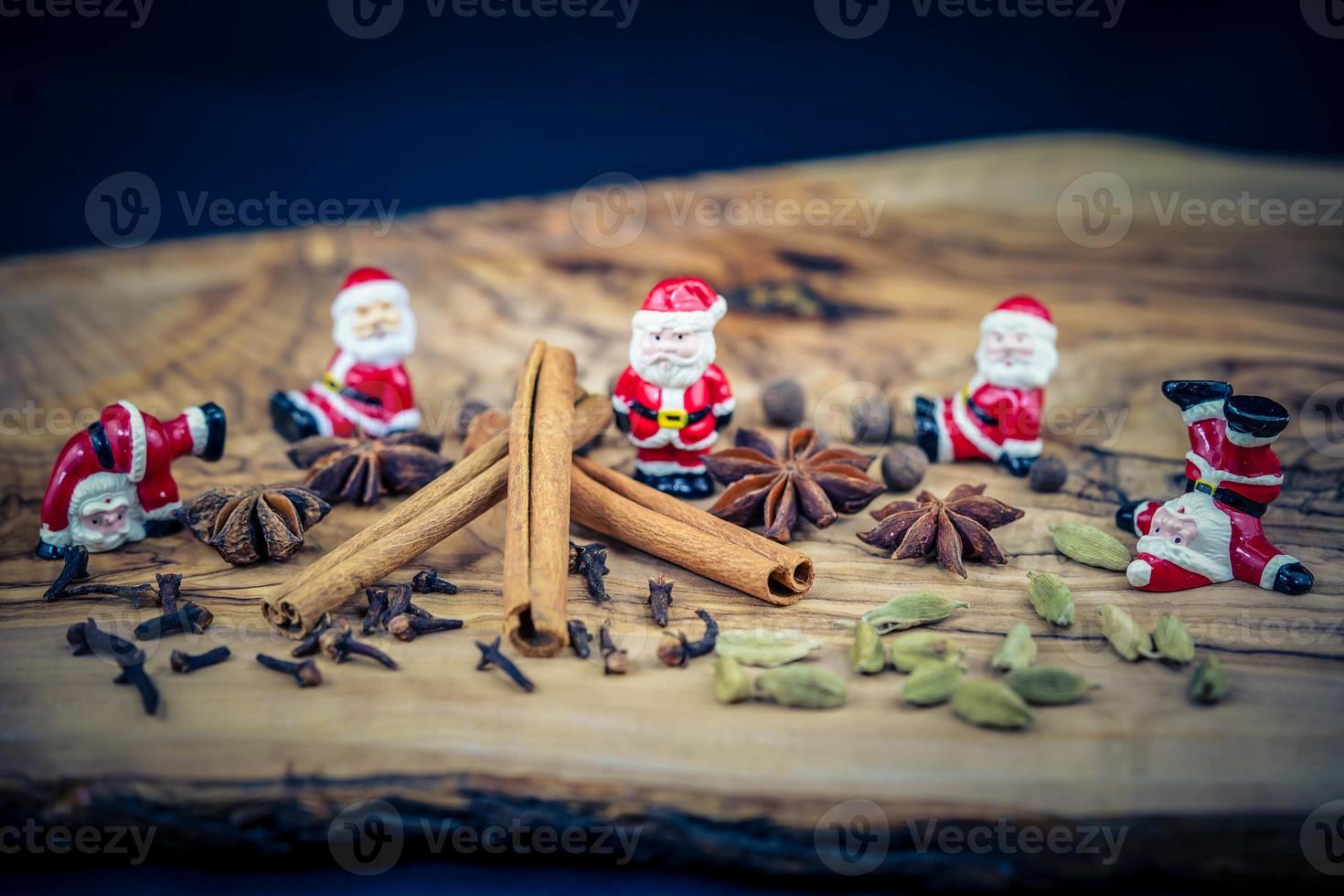 bonecos de papai noel e especiarias de natal em madeira de oliveira foto