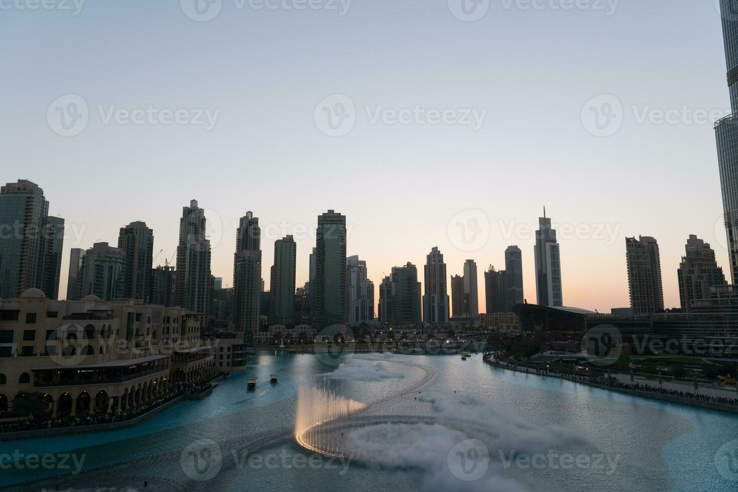 dubai cantando fontes às noite lago Visão entre arranha-céus. cidade Horizonte dentro crepúsculo moderno arquitetura dentro eua capital centro da cidade. foto