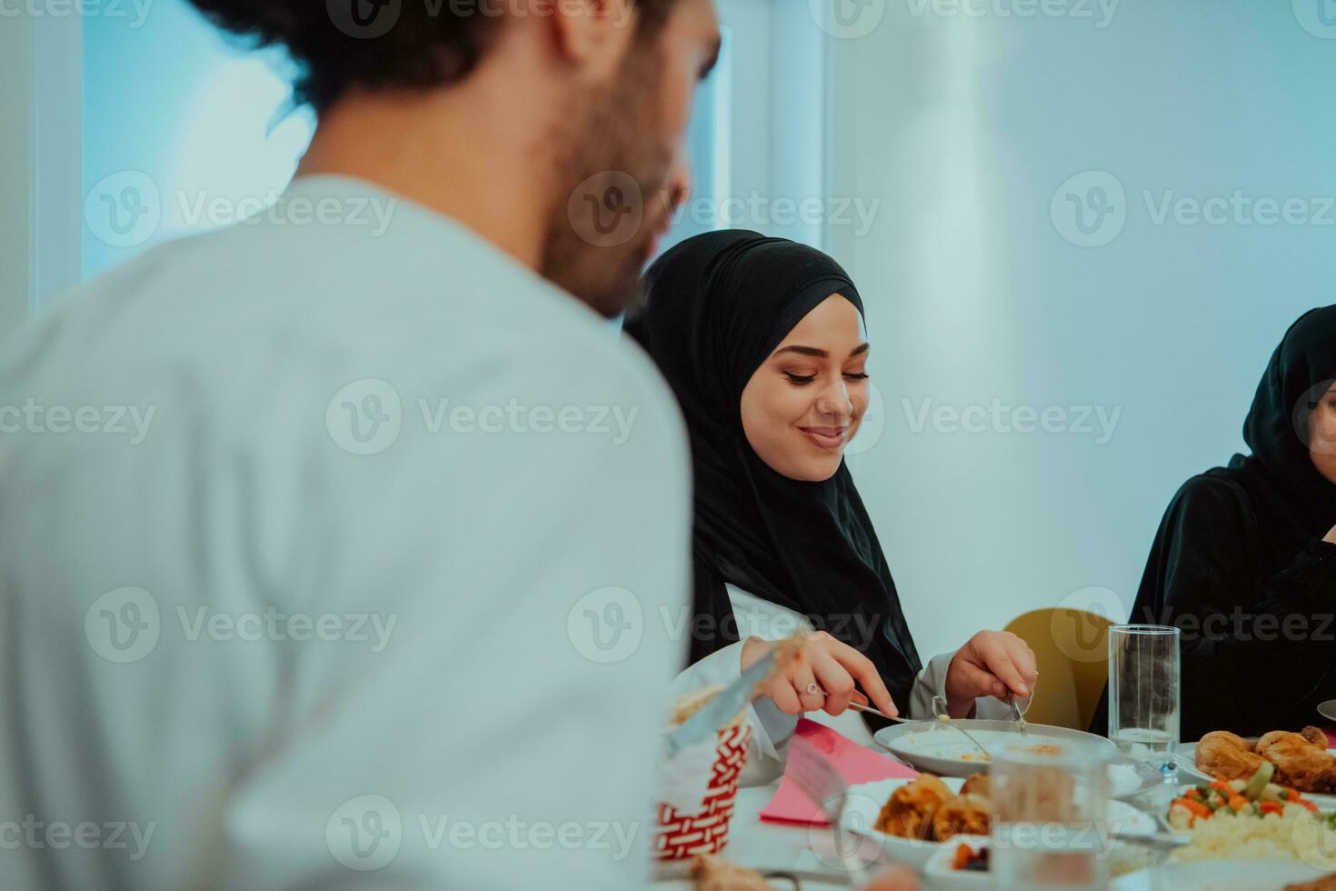 muçulmano família tendo iftar jantar bebendo água para pausa celebração. comendo tradicional Comida durante Ramadã festa mês às lar. a islâmico halal comendo e bebendo dentro moderno casa foto