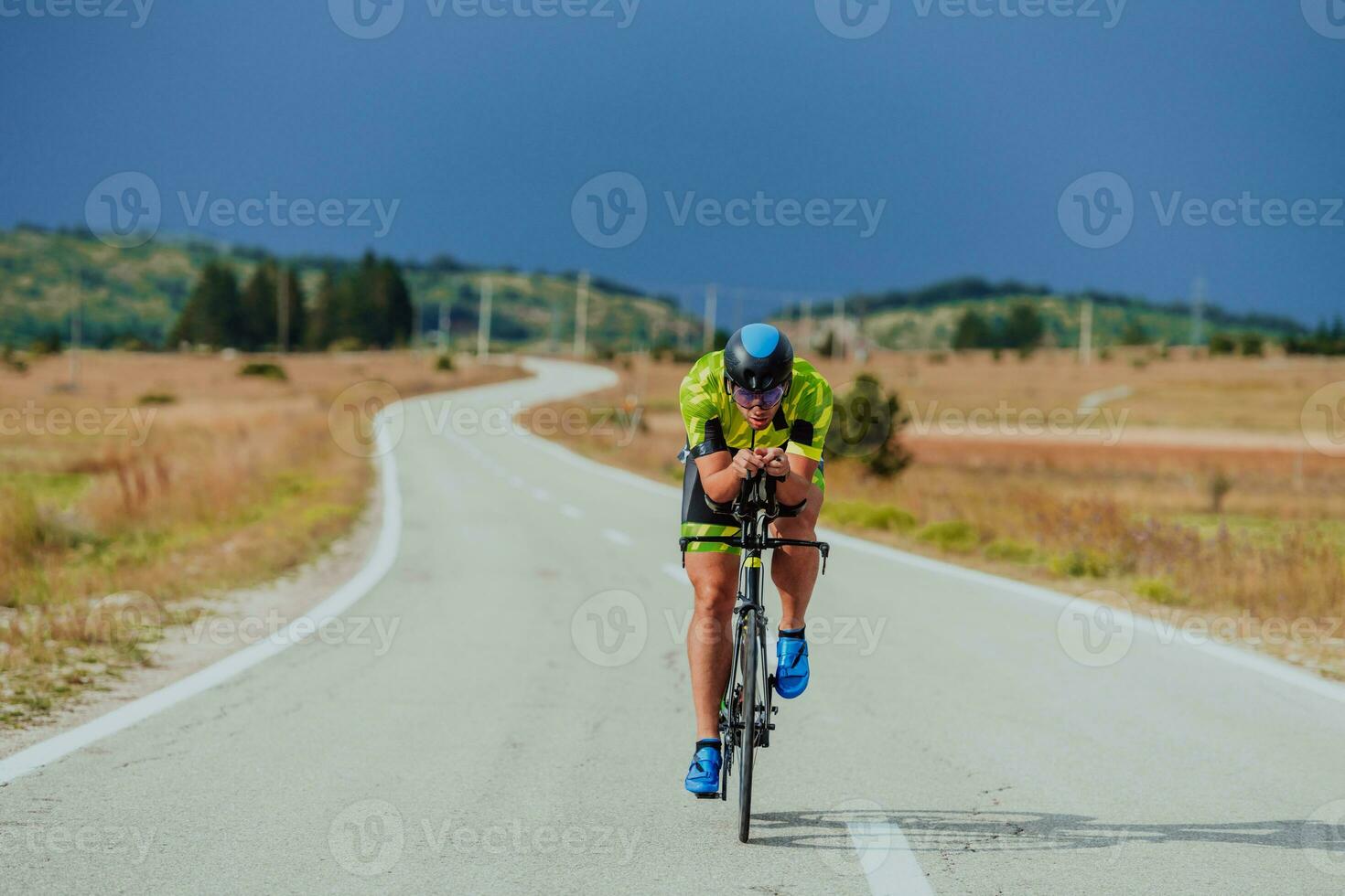 cheio comprimento retrato do a ativo triatleta dentro roupa de esporte e com uma protetora capacete equitação uma bicicleta. seletivo foco foto