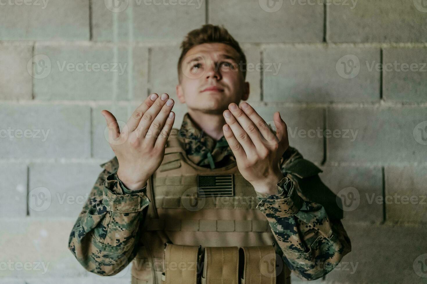 uma muçulmano soldado do a especial forças ora para Deus de levantando dele mãos e começa uma oração foto