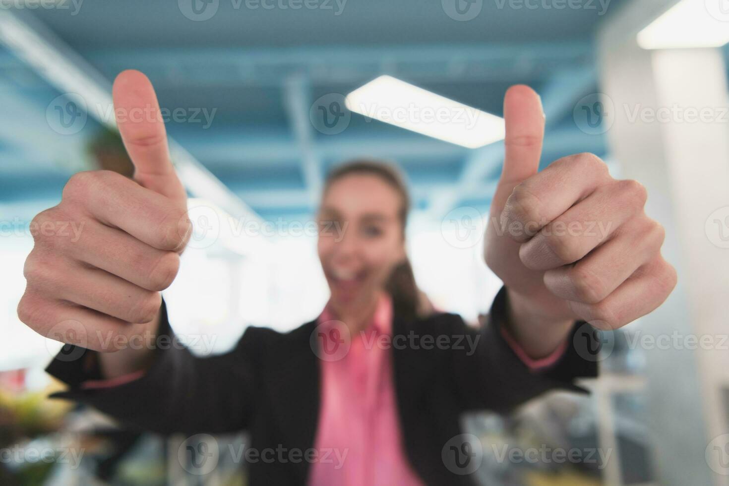 lindo alegre mulher de negócios mostrando Duplo polegar para cima advertir às local de trabalho dentro criativo aberto espaço coworking escritório foto