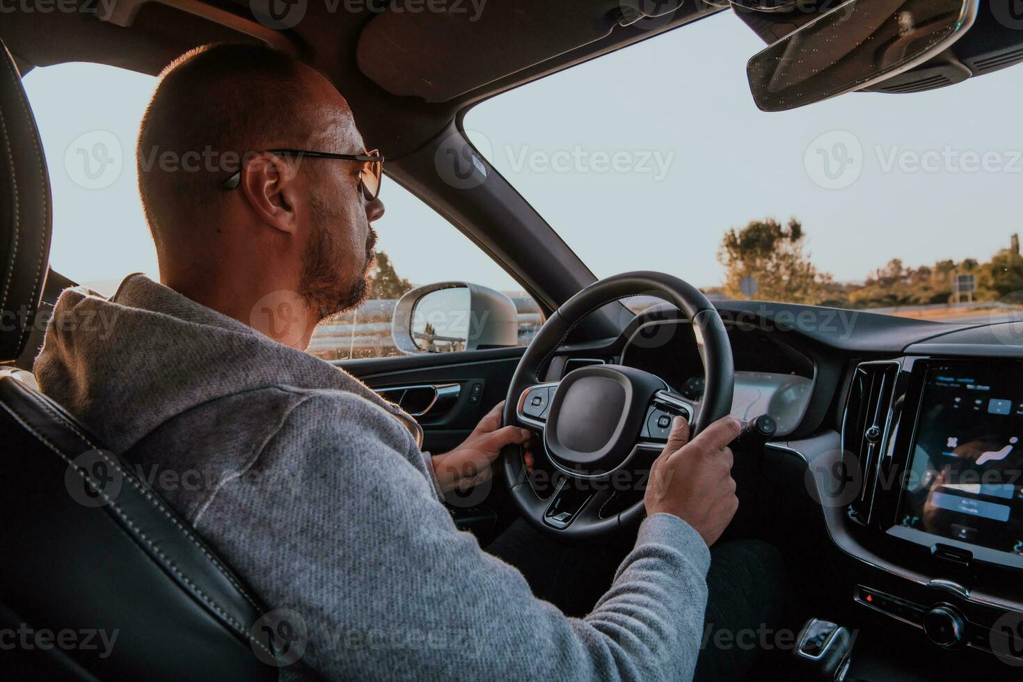 uma homem com uma oculos de sol dirigindo uma carro às pôr do sol. a conceito do carro viagem foto
