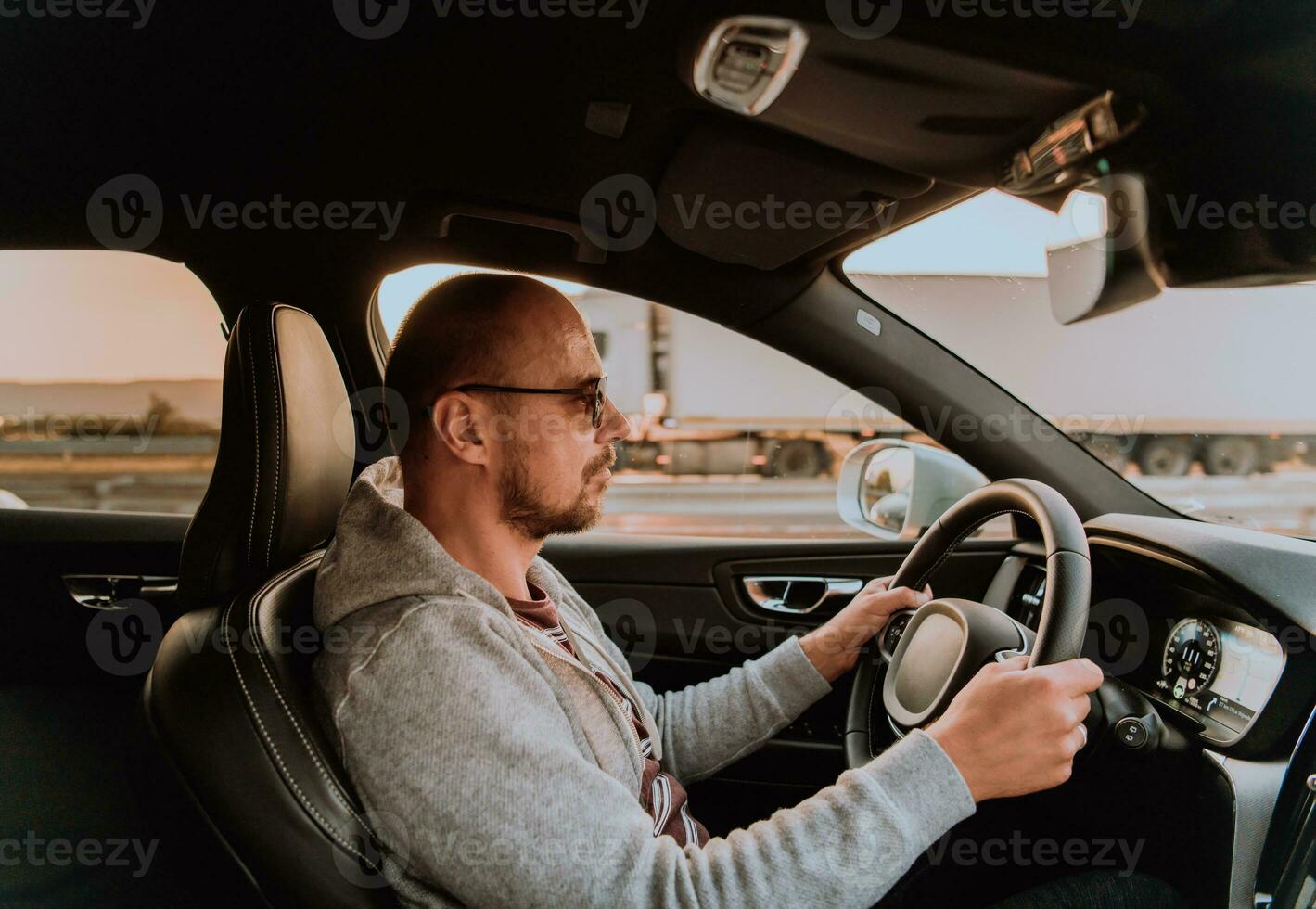 uma homem com uma oculos de sol dirigindo uma carro às pôr do sol. a conceito do carro viagem foto