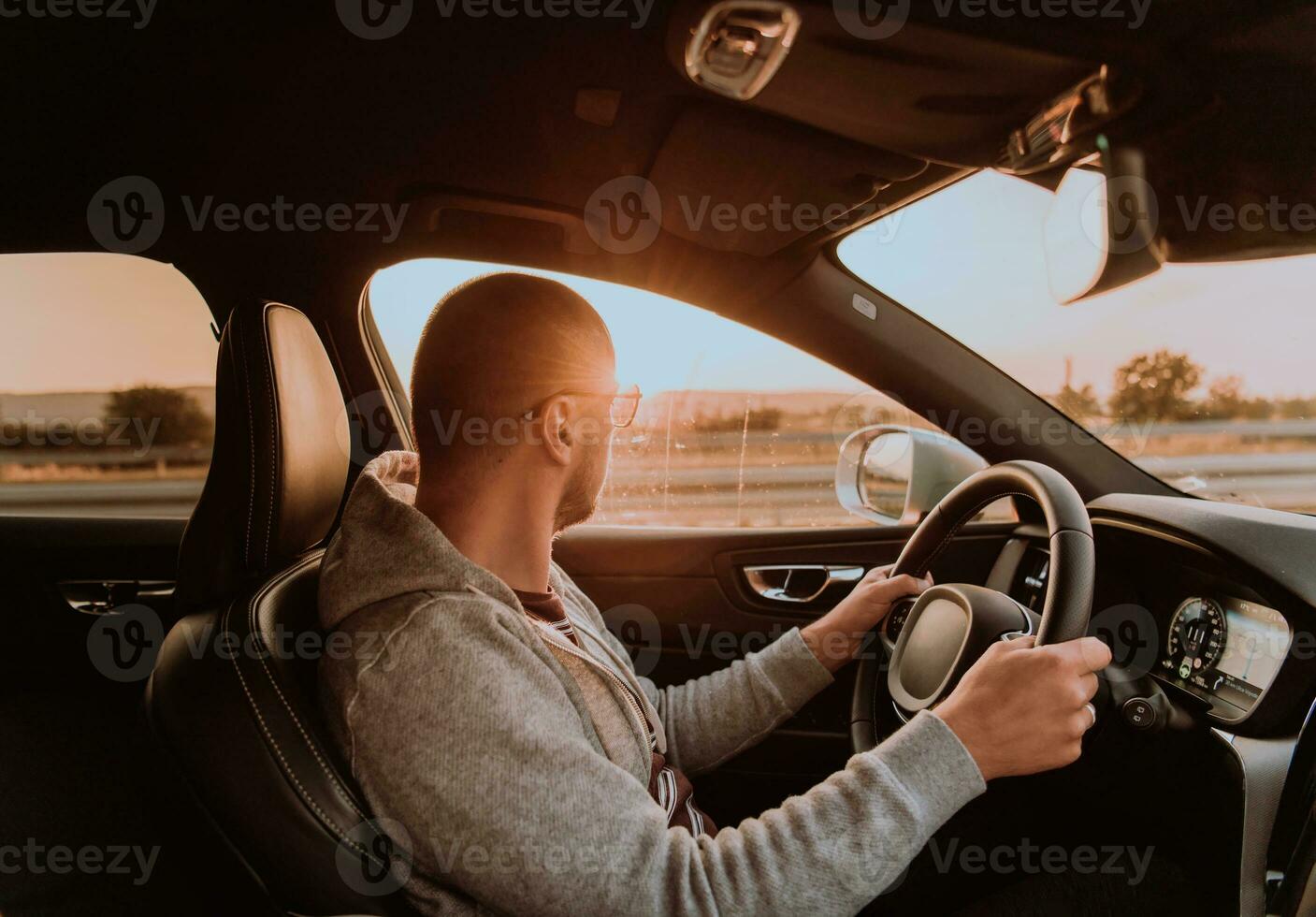 uma homem com uma oculos de sol dirigindo uma carro às pôr do sol. a conceito do carro viagem foto