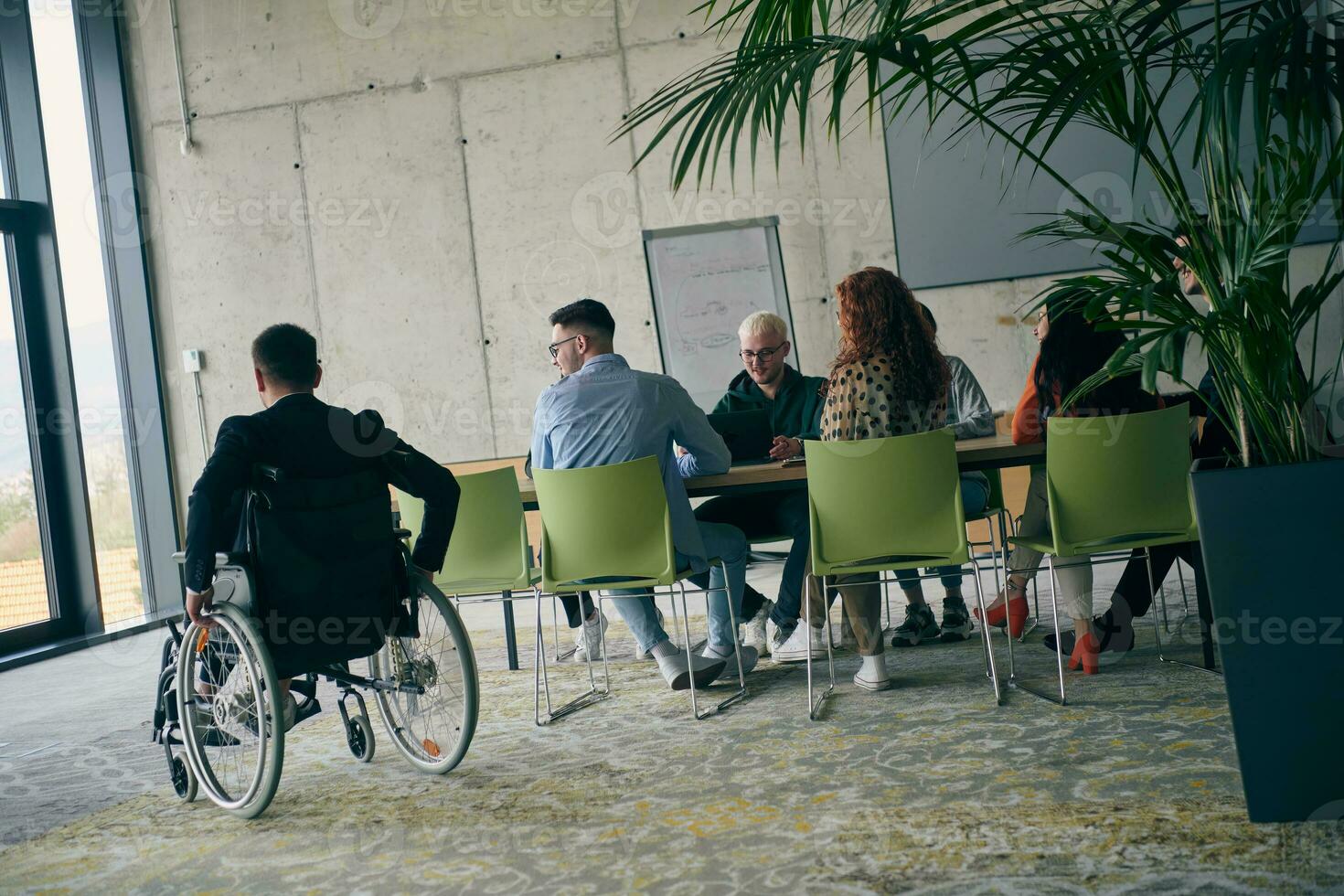 uma diverso grupo do o negócio profissionais, Incluindo a pessoa com uma incapacidade, colhido às uma moderno escritório para uma produtivo e inclusivo reunião. foto