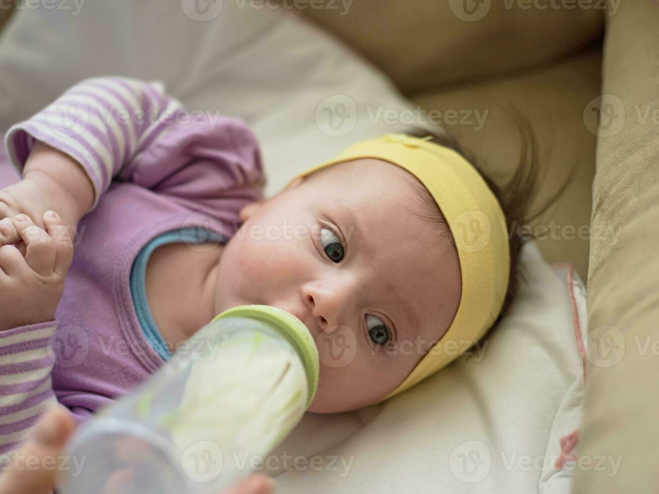 bebe comendo leite da mamadeira foto