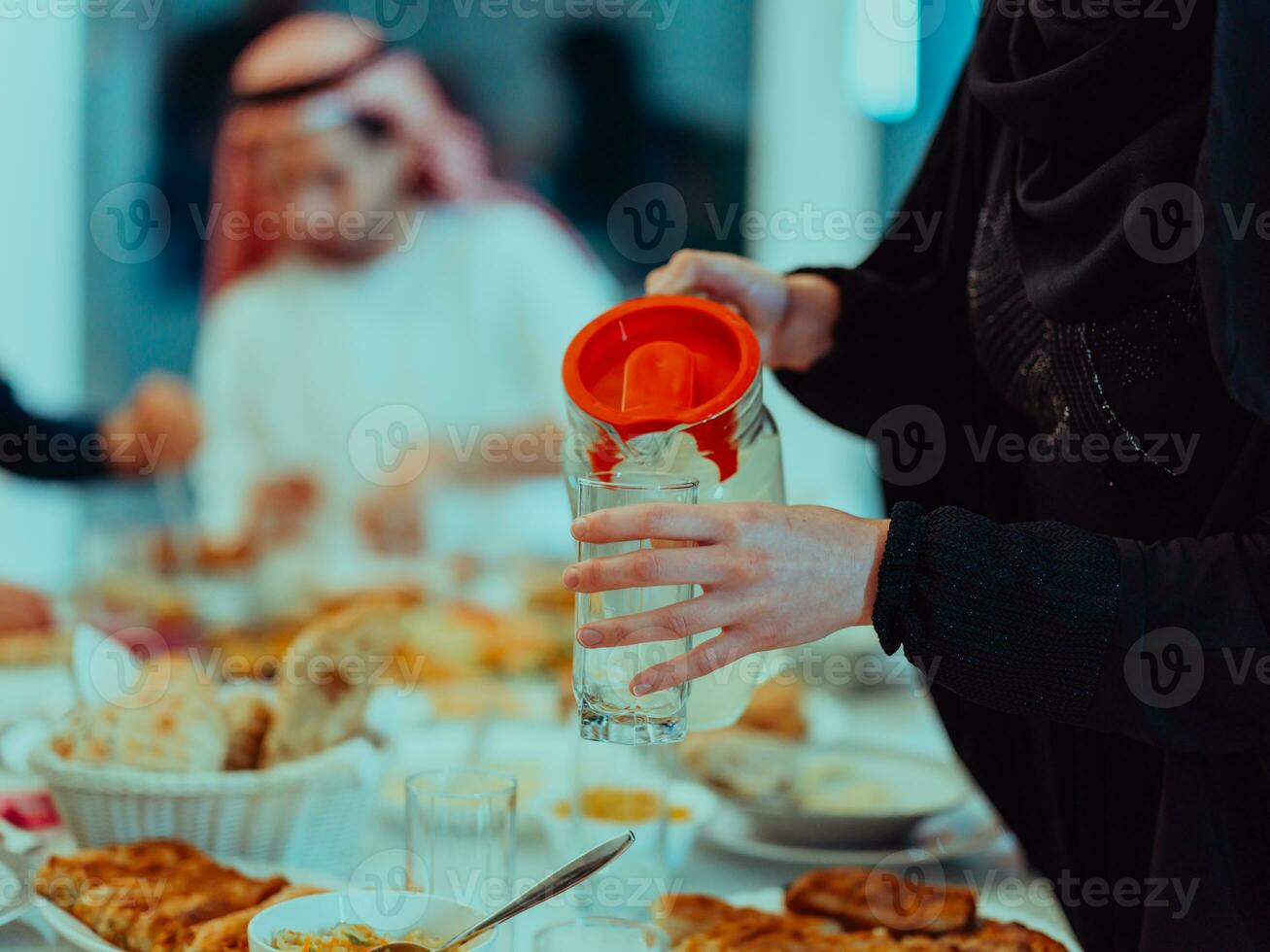 eid Mubarak muçulmano família tendo iftar jantar bebendo água para pausa celebração. comendo tradicional Comida durante Ramadã festa mês às lar. a islâmico halal comendo e bebendo foto