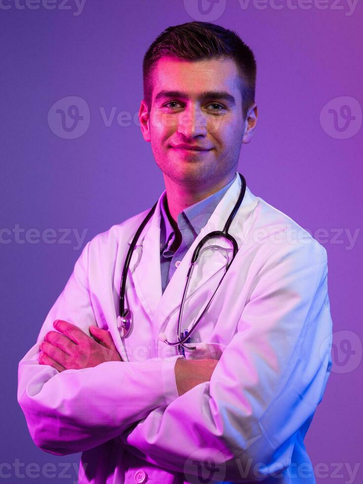 retrato do herói dentro branco casaco. alegre sorridente jovem médico com estetoscópio dentro médico hospital em pé contra azul e Rosa fundo. coronavírus covid-19 Perigo alerta foto