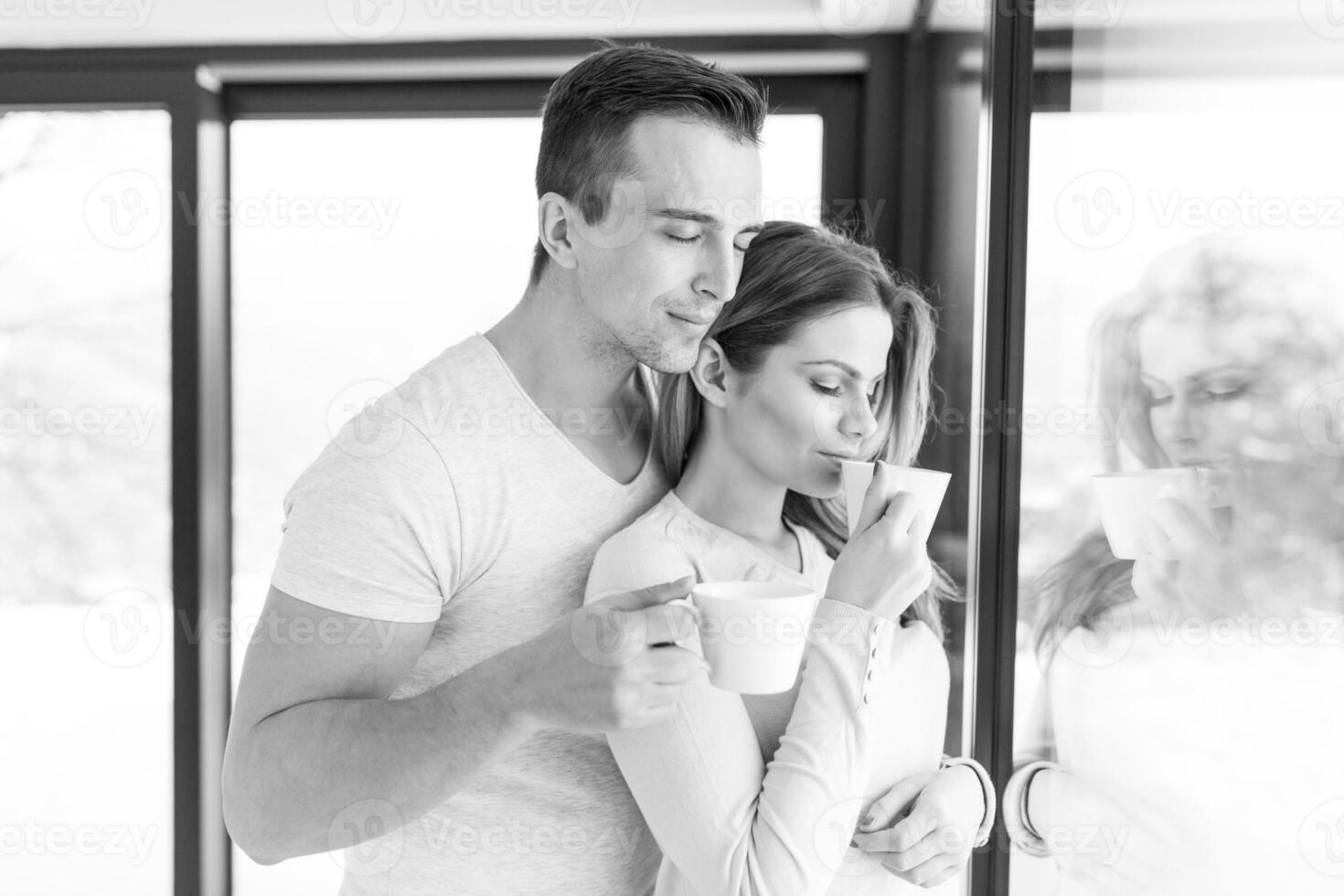 jovem casal desfrutando de café da manhã pela janela foto