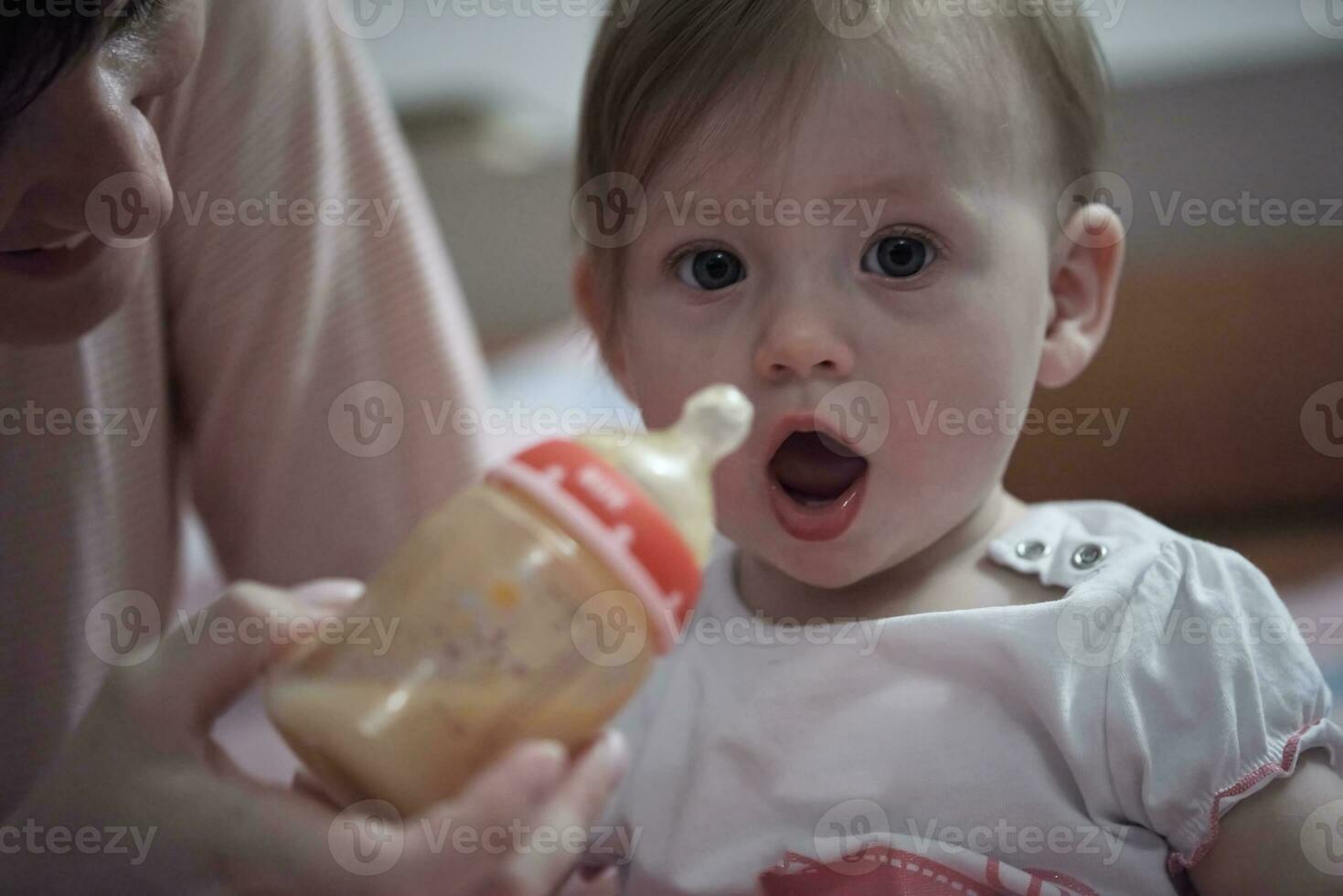 pequeno bebê bebendo suco a partir de garrafa foto