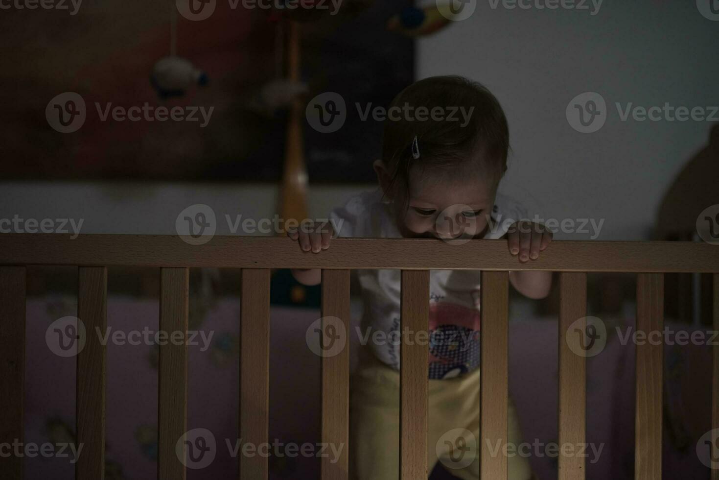 lindo bebezinho de um ano e dando os primeiros passos na cama foto