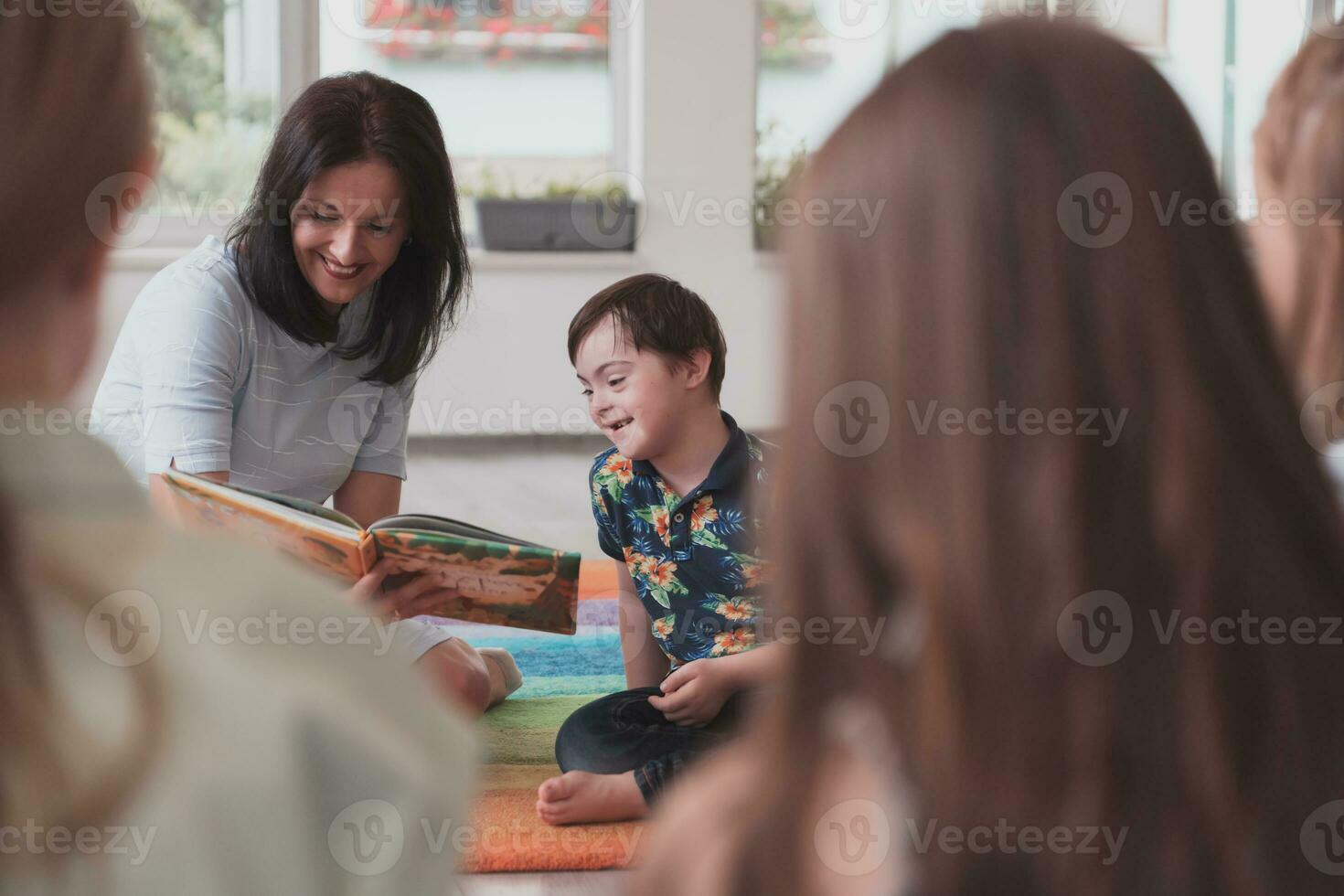 lendo Tempo dentro a elementar escola ou Jardim da infância, uma professor lê uma livro para crianças dentro a elementar escola ou Jardim da infância. a conceito do pré escola Educação. seletivo foco foto