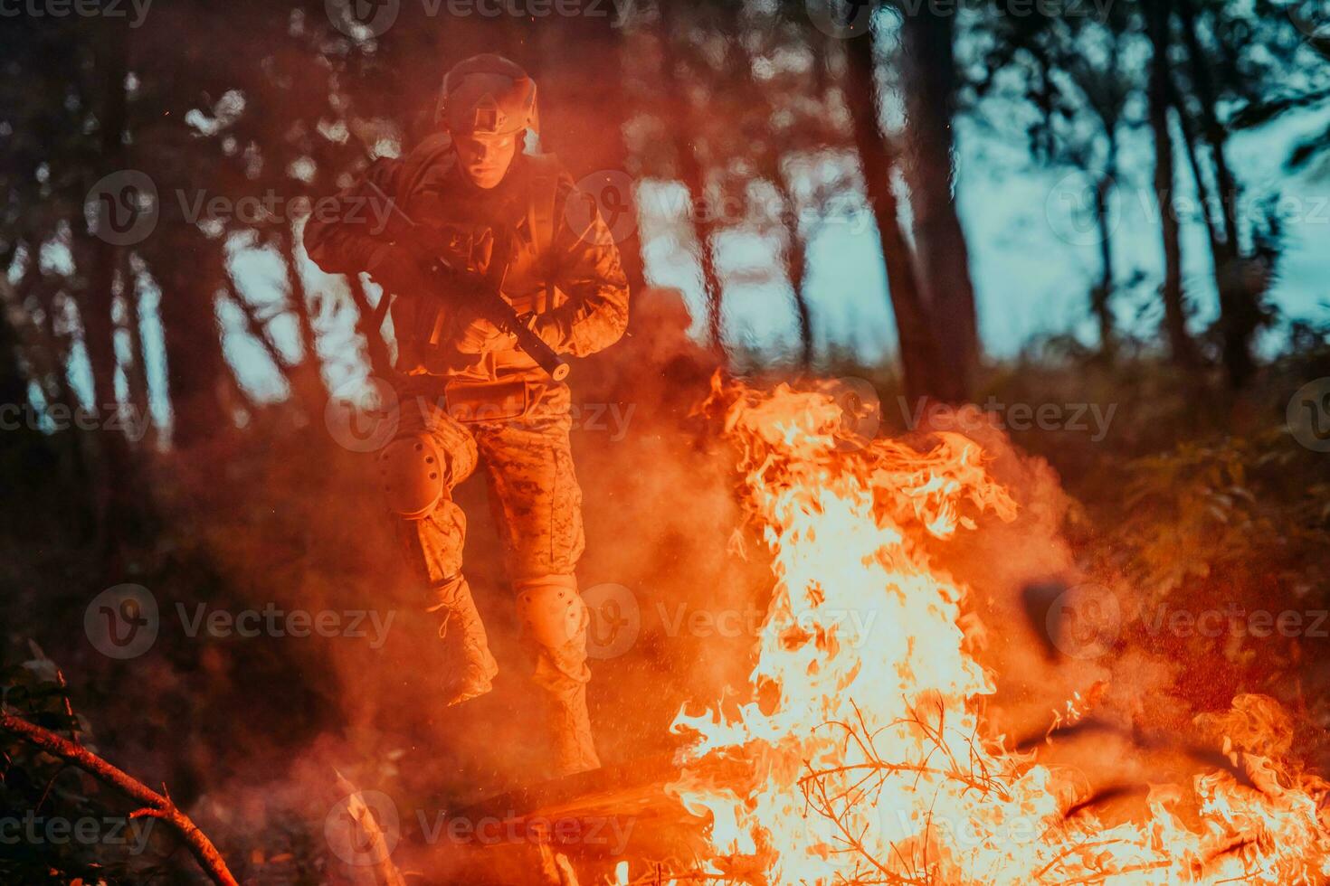 soldado dentro açao às noite dentro a floresta área. noite Tempo militares missão pulando sobre fogo foto