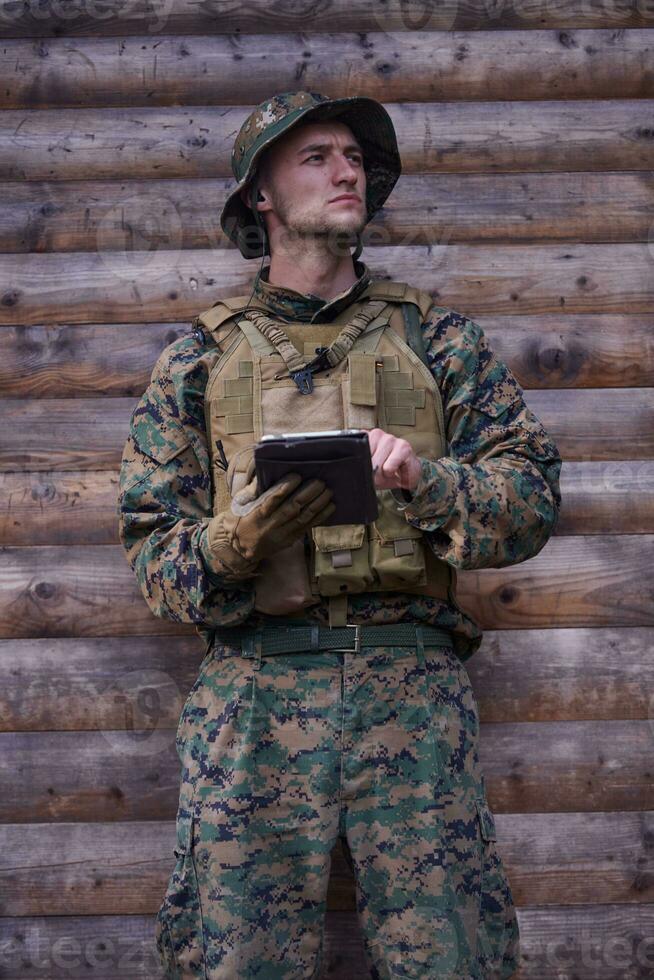 soldado usando computador tablet no acampamento militar foto