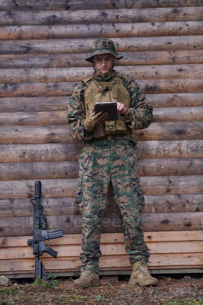 soldado usando computador tablet no acampamento militar foto