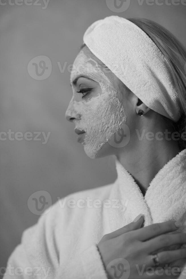 mulher de spa aplicando máscara facial foto