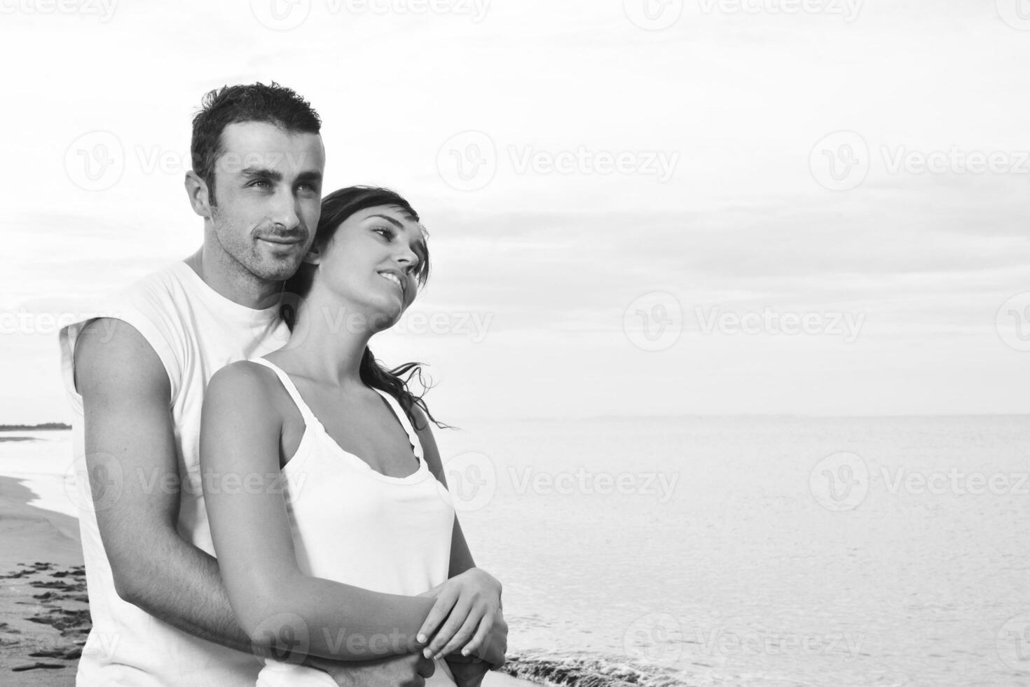 feliz casal jovem se diverte na bela praia foto