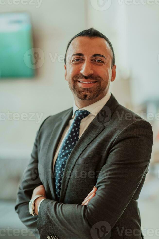 retrato do uma homem de negocios dentro uma terno com dele braços cruzado dentro uma moderno escritório construção foto