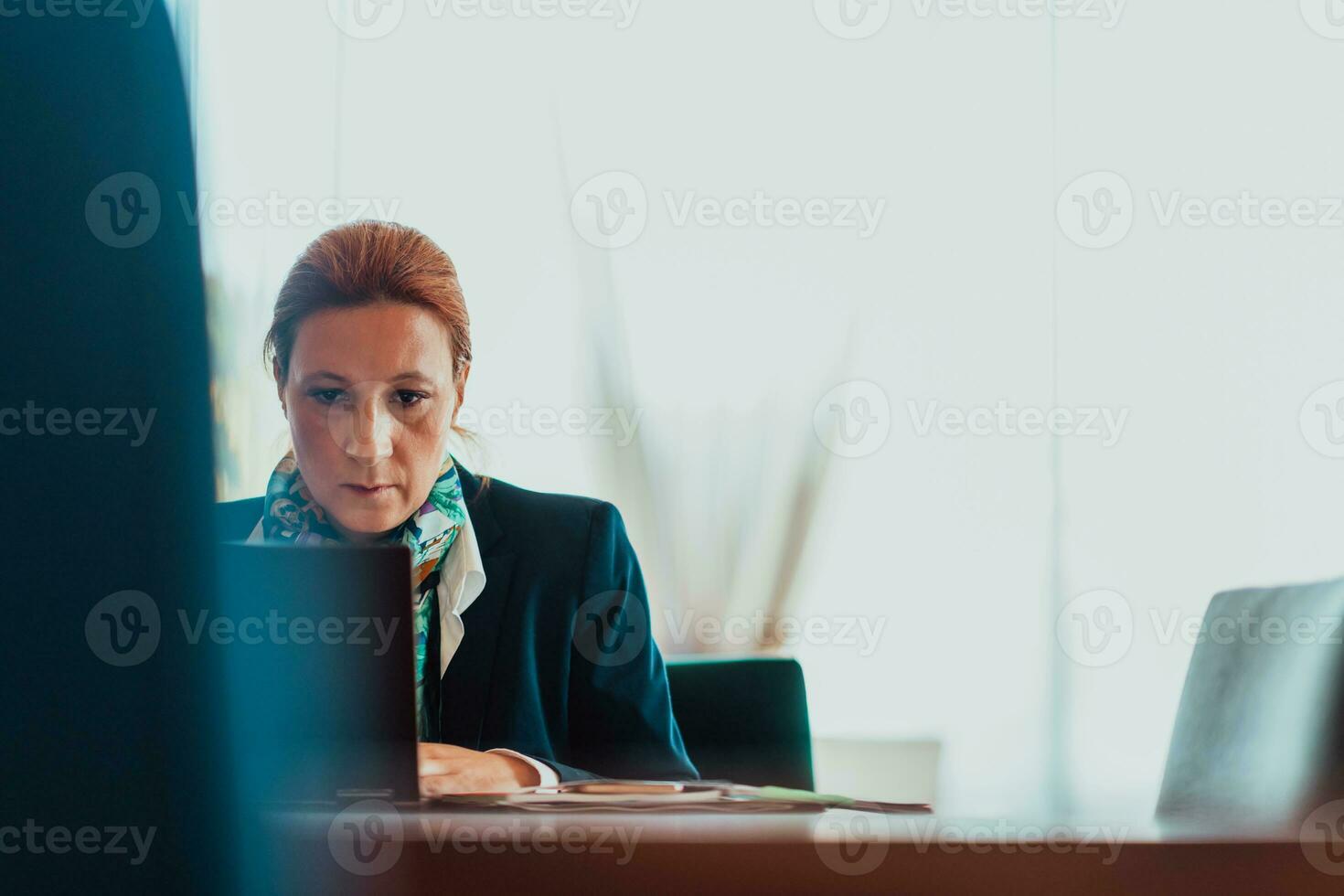 foto do a idosos mulher usando uma computador portátil para levar Fora o negócio projetos e tarefas enquanto sentado dentro uma moderno corporação