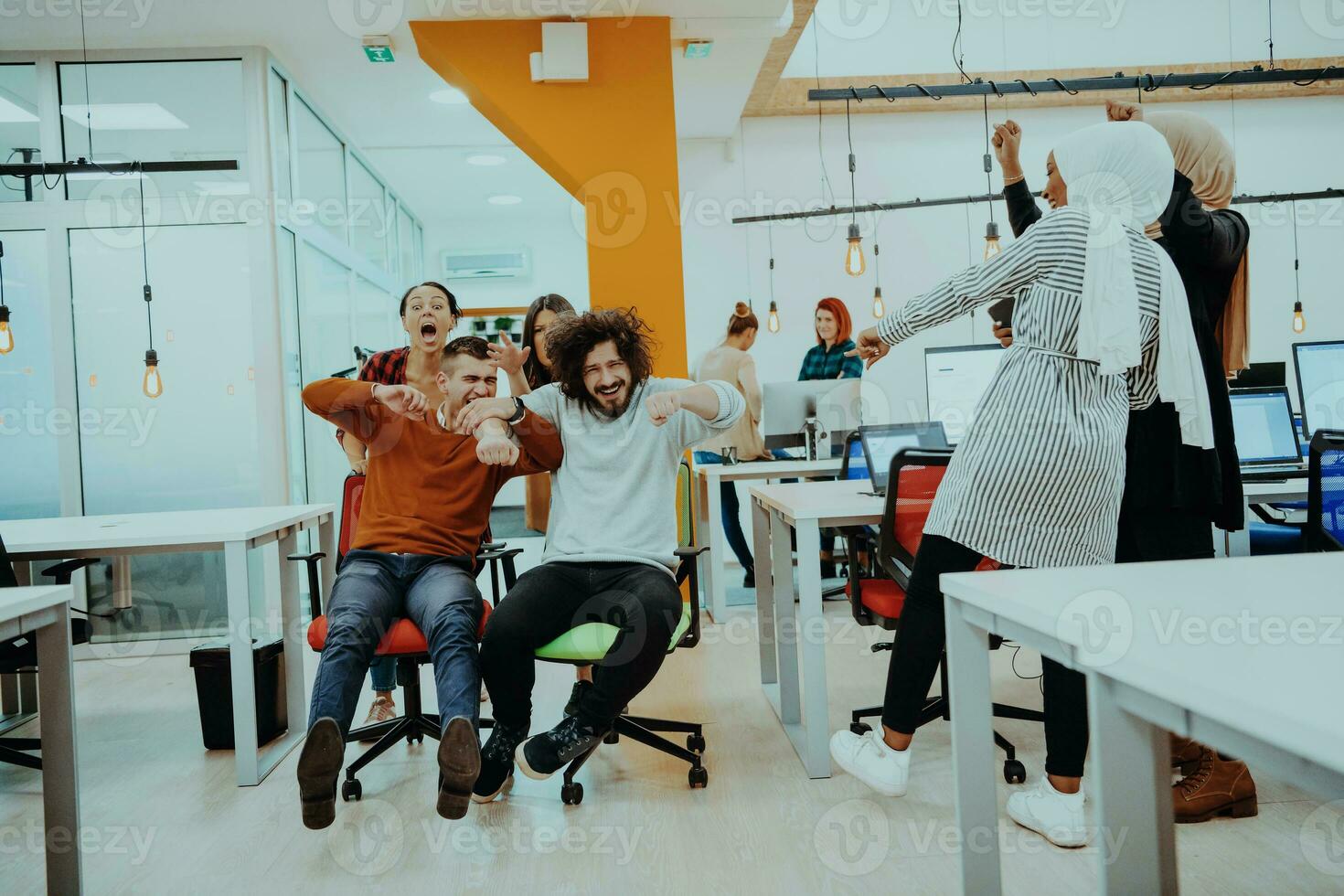 equipe construção e escritório Diversão. jovem alegre pessoas de negócio dentro inteligente casual vestem tendo Diversão enquanto corrida em escritório cadeiras e sorridente. foto