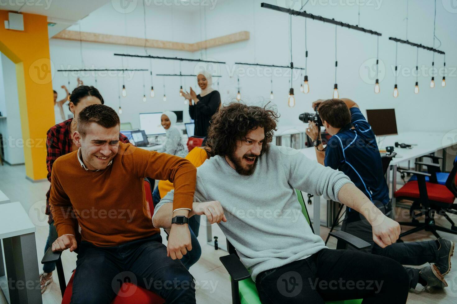 equipe construção e escritório Diversão. jovem alegre pessoas de negócio dentro inteligente casual vestem tendo Diversão enquanto corrida em escritório cadeiras e sorridente. foto