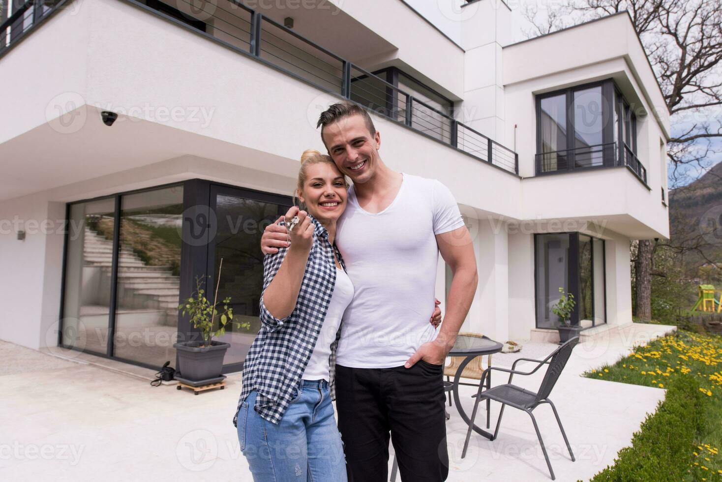 casal se abraçando em frente a nova casa de luxo foto