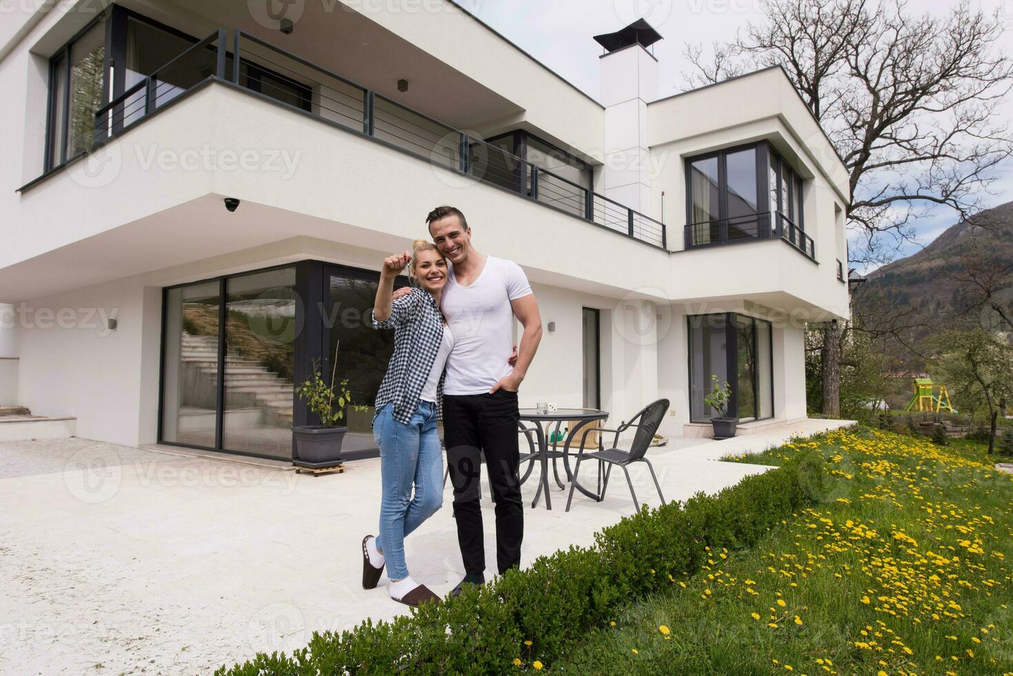 casal se abraçando em frente a nova casa de luxo foto