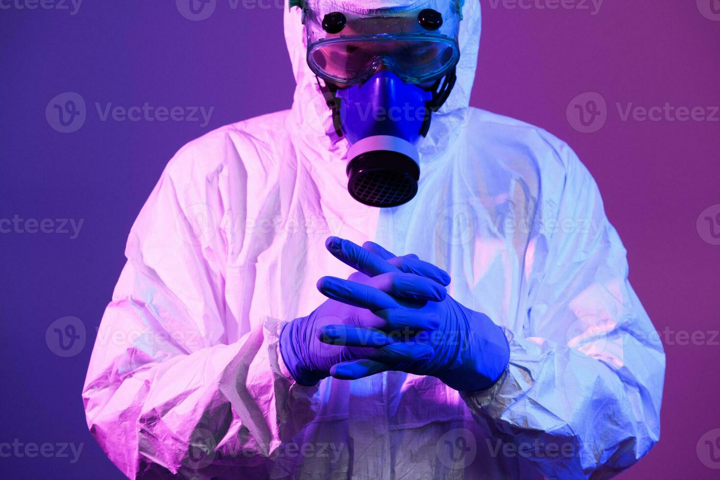 coronavírus covid-19 pandemia. médico cientista vestindo protetora biológico terno e mascarar vencimento para global cuidados de saúde epidemia Atenção e Perigo fundo dentro azul e Rosa néon luzes fundo. foto