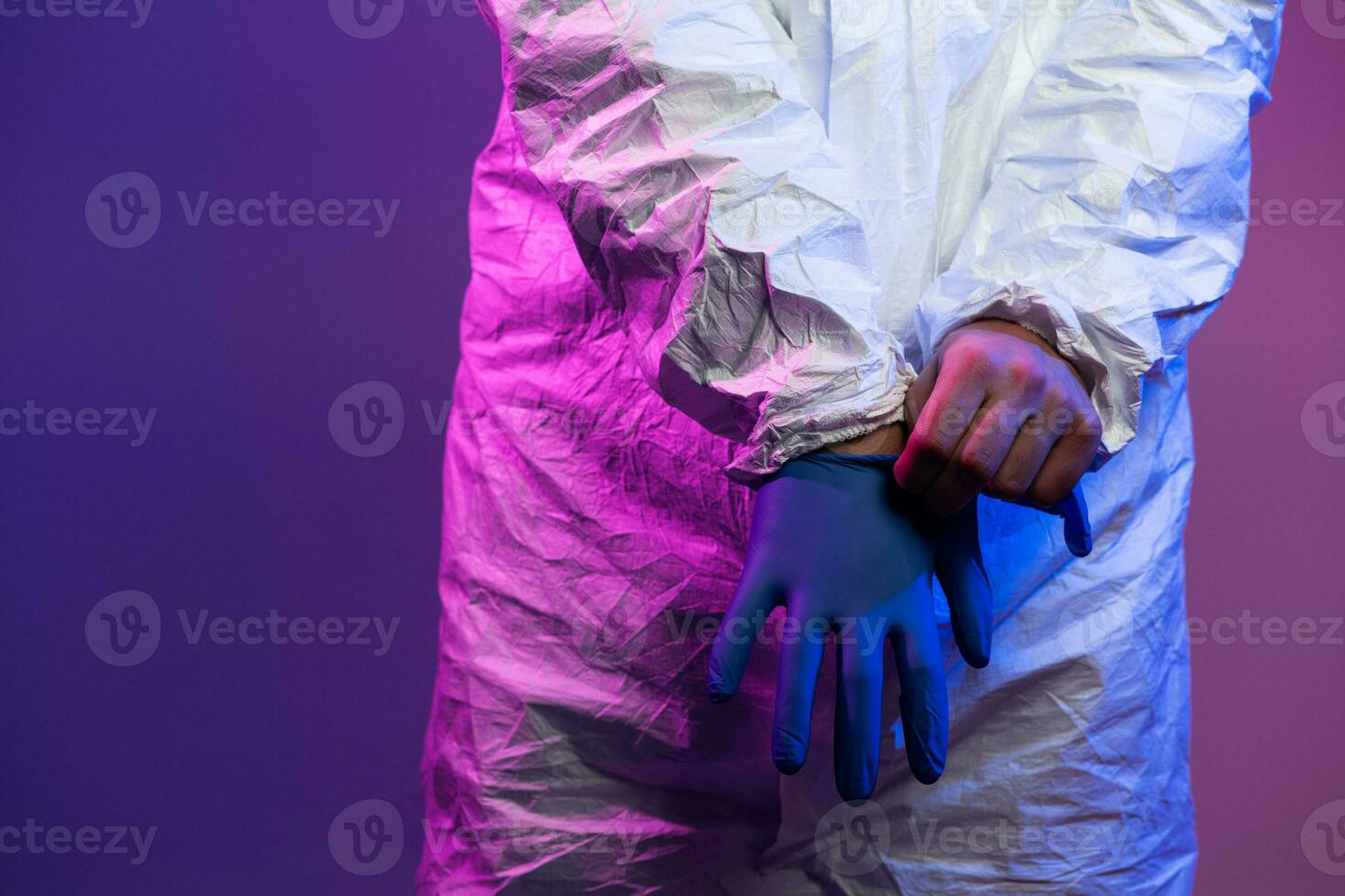 coronavírus covid-19 pandemia. médico cientista vestindo protetora biológico terno e mascarar vencimento para global cuidados de saúde epidemia Atenção e Perigo fundo dentro azul e Rosa néon luzes fundo. foto