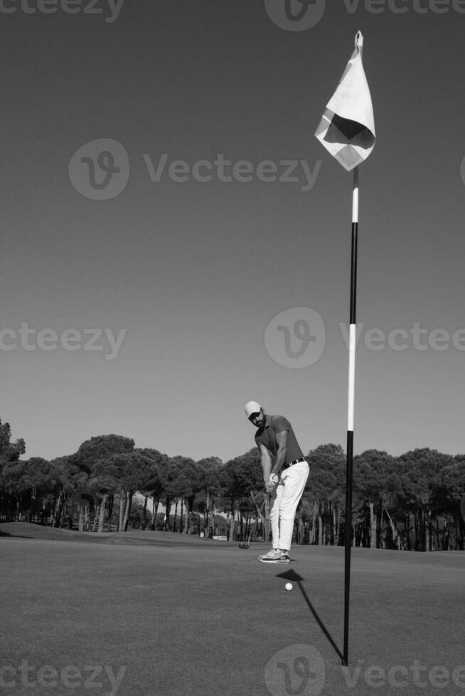 jogador de golfe acertando tiro em dia ensolarado foto