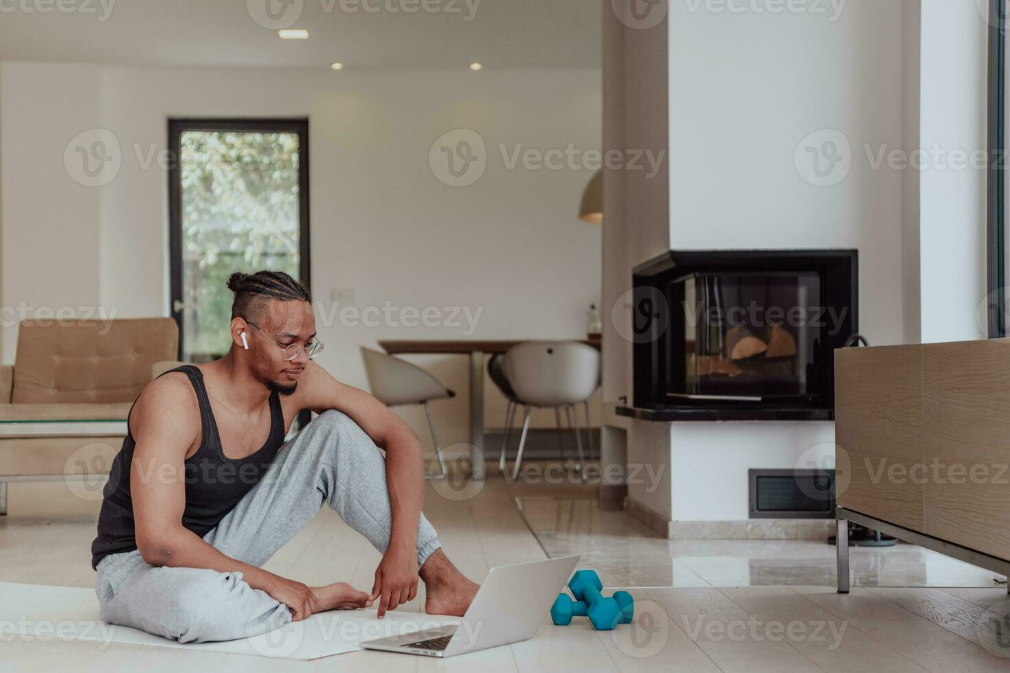 Treinamento às lar. desportivo homem fazendo Treinamento enquanto assistindo conectados tutorial em computador portátil, exercício dentro vivo sala, livre espaço foto