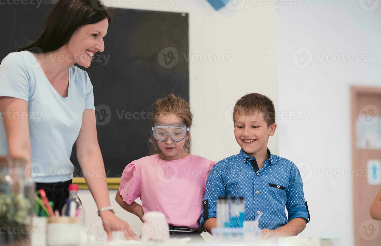 elementar escola Ciência Sala de aula entusiasmado professor explica química para diverso grupo do crianças, pequeno Garoto mistura produtos químicos dentro copos. crianças aprender com interesse foto