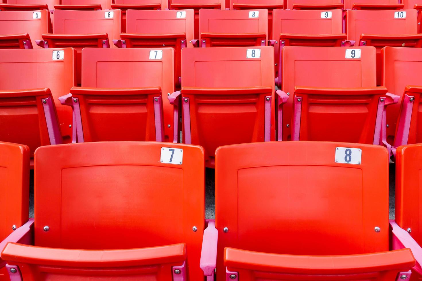 fila de cadeiras dobráveis vermelhas em um estádio. foto