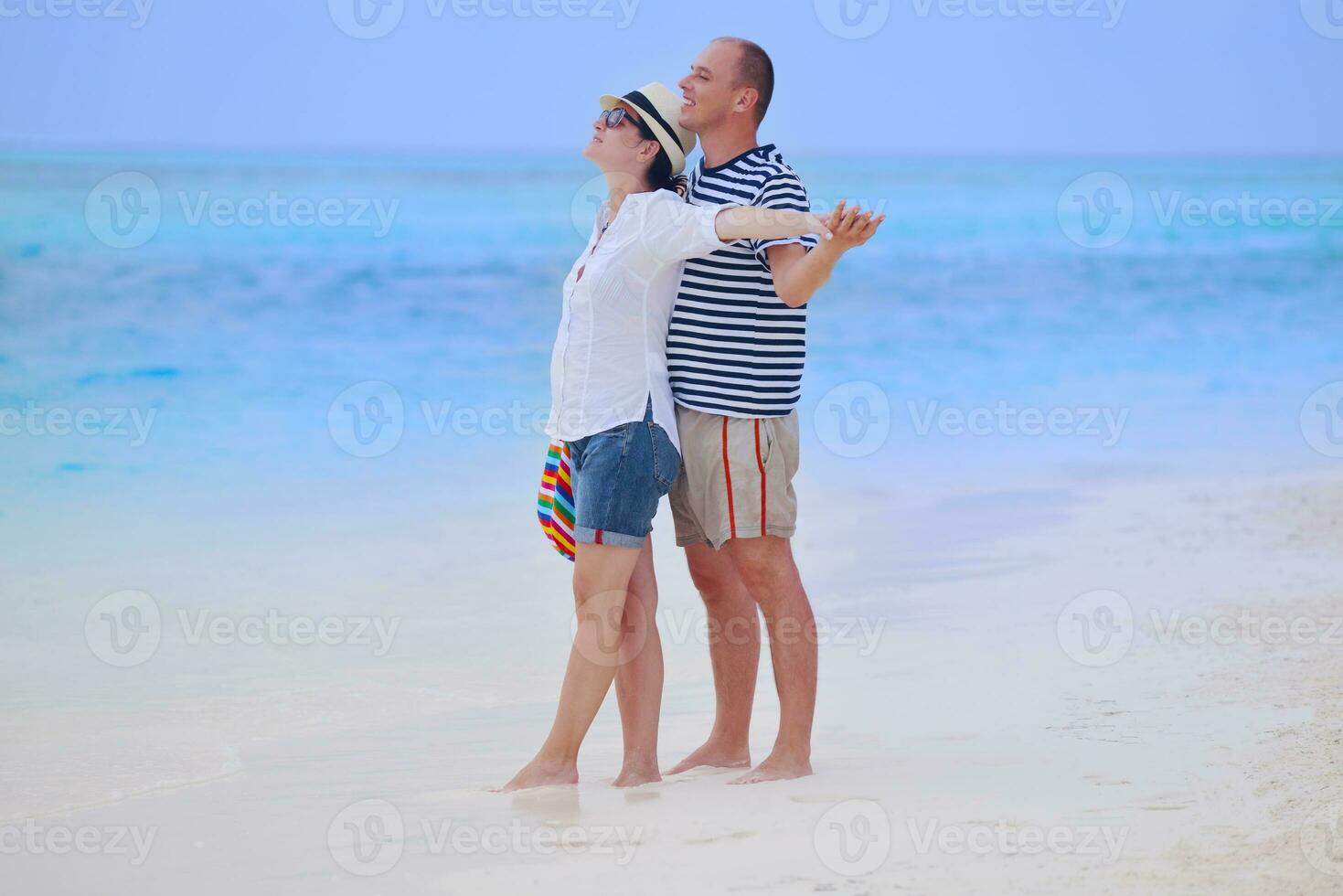 feliz casal jovem se divertir na praia foto