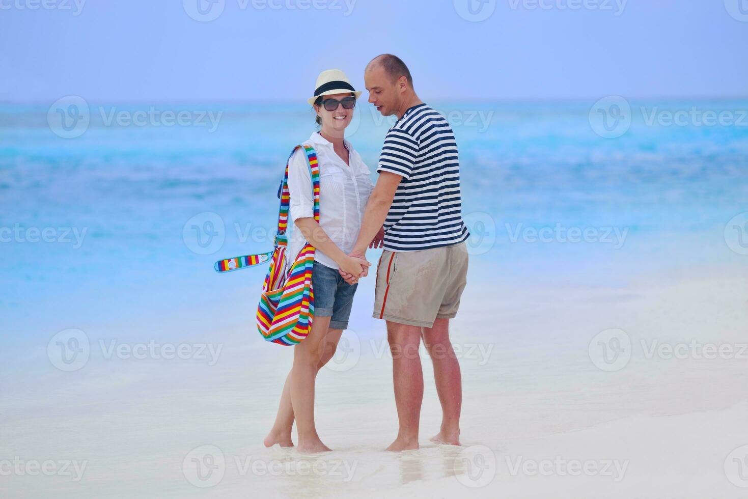 feliz casal jovem se divertir na praia foto