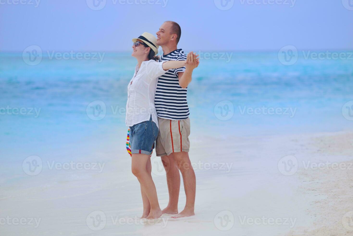 feliz casal jovem se divertir na praia foto