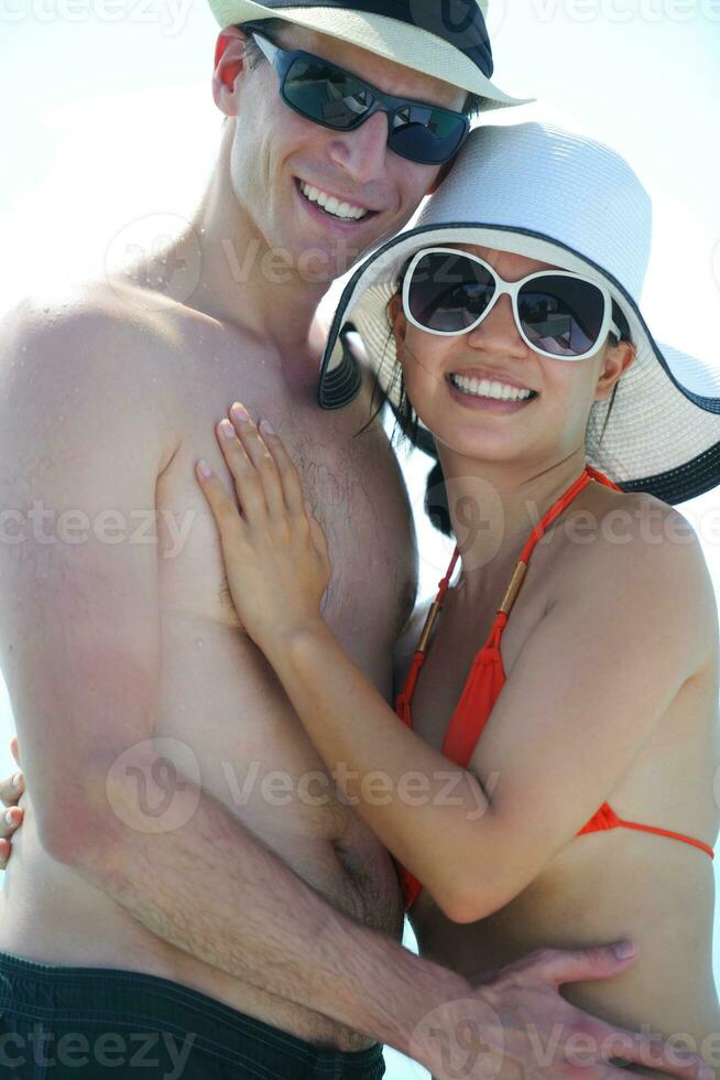 feliz casal jovem se divertir na praia foto