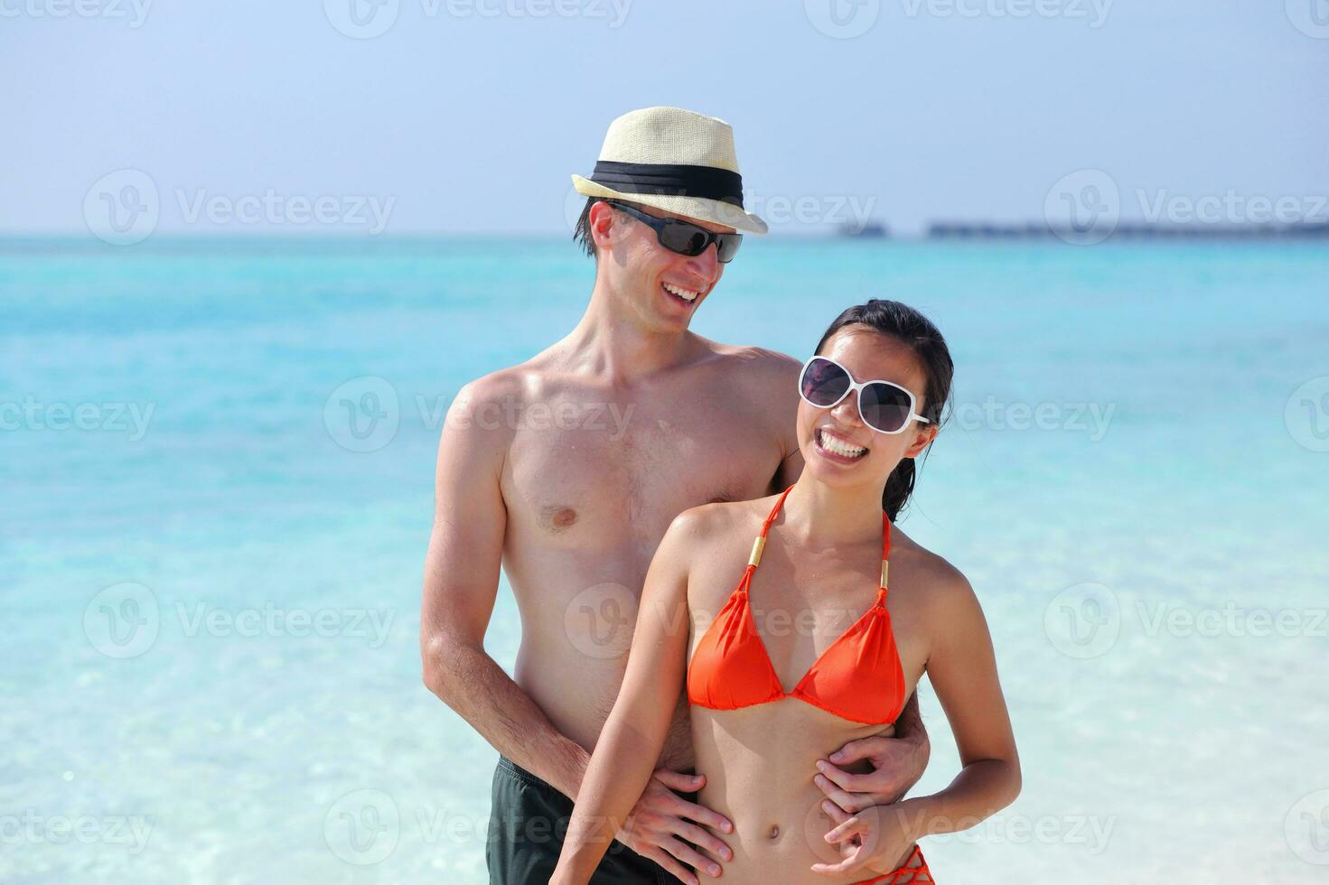 feliz casal jovem se divertir na praia foto