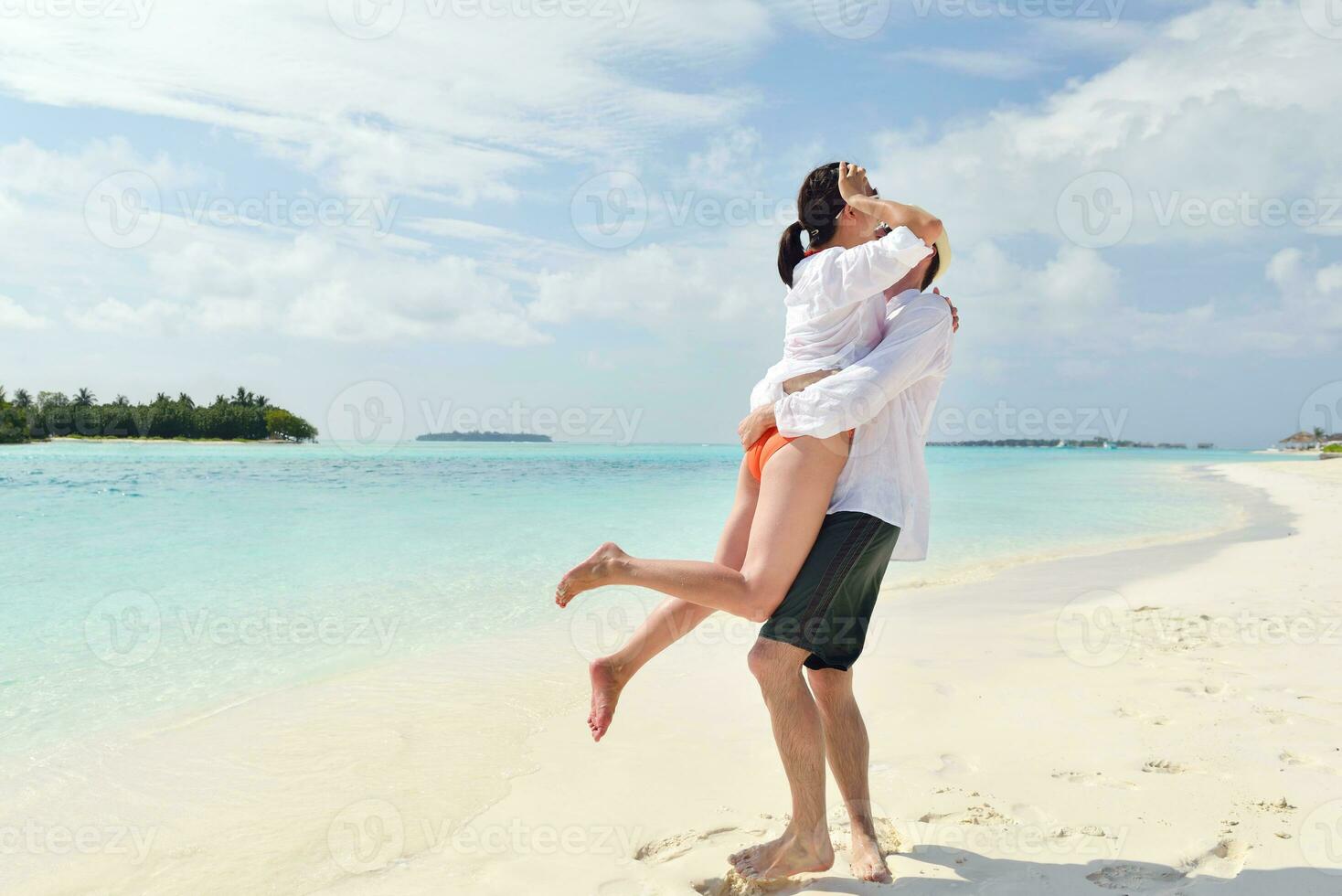 feliz casal jovem se divertir na praia foto