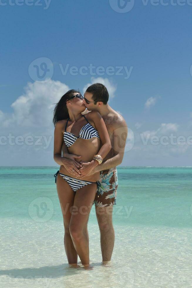 feliz casal jovem se divertir na praia foto