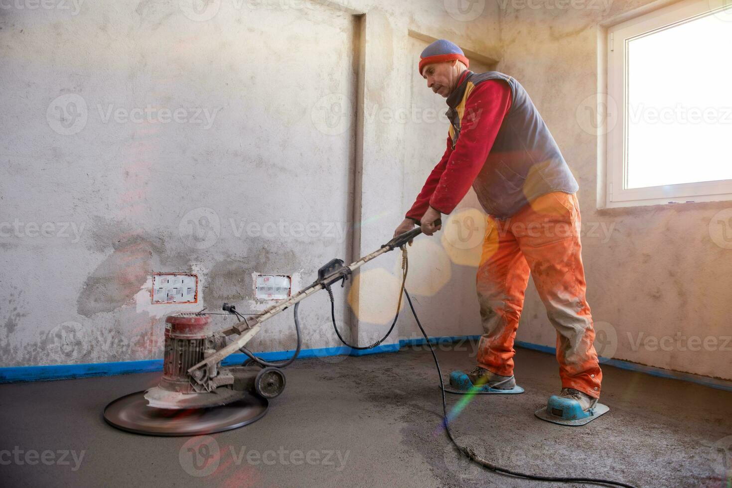 trabalhador realizando e polindo piso de betonilha de areia e cimento foto