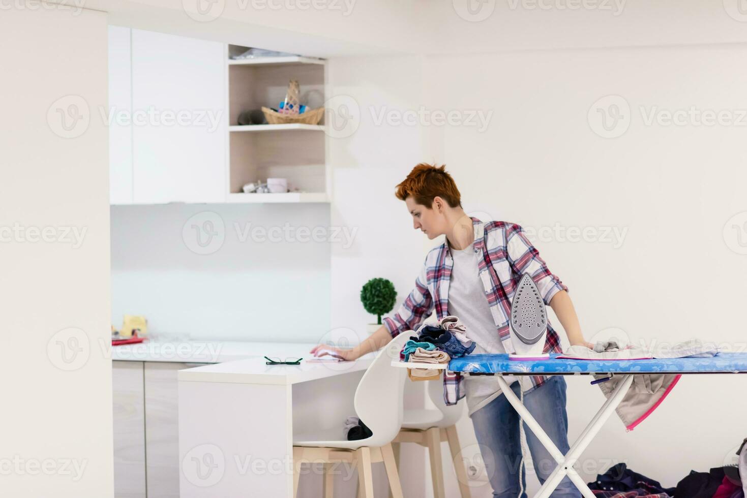 mulher ruiva passando roupa em casa foto