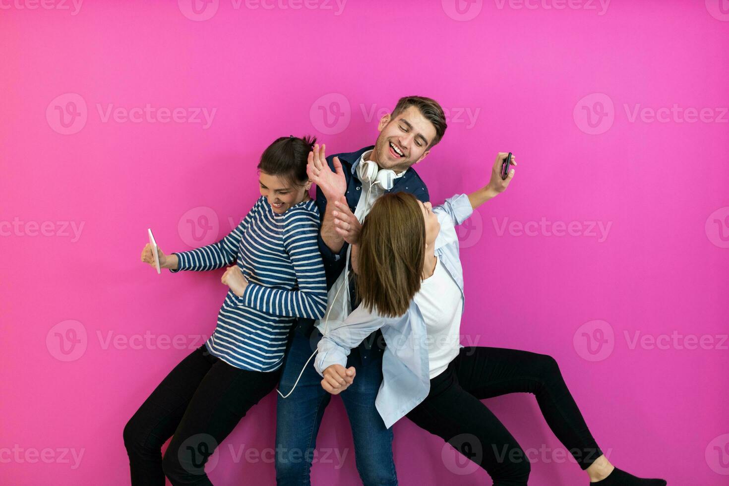 grupo do jovem pessoas dentro moderno roupas posando e tendo Diversão isolado dentro frente do Rosa fundo foto