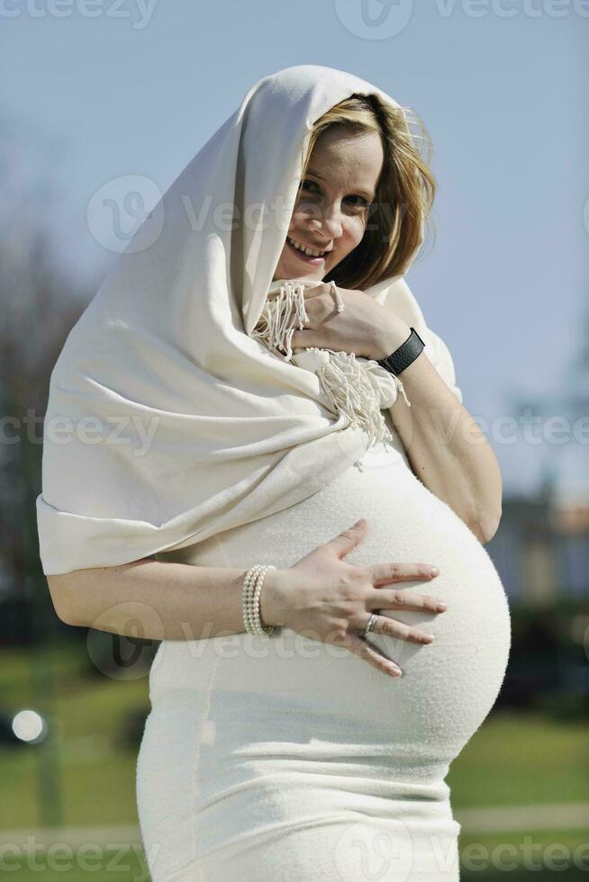 feliz jovem grávida ao ar livre foto